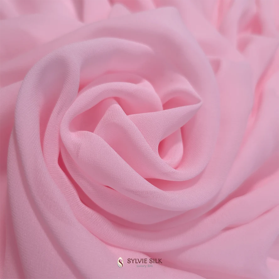 Soft pink silk georgette fabric arranged in flowing rosette-like folds