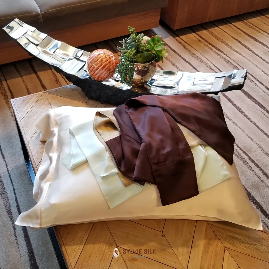 Sylvie Silk pillowcase with coordinating silk fabrics draped across a wood table