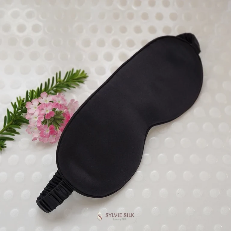 Black silk sleep mask with gathered silk-covered elastic band and pink flowers